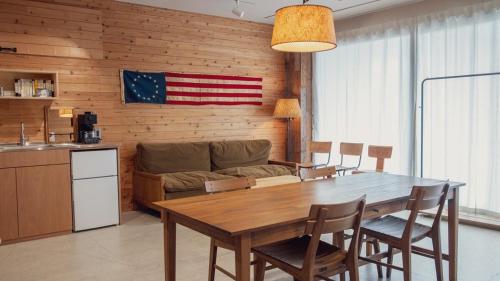 a kitchen and dining room with a table and a couch at 衣食住が楽しめるデザイナーズホテル E-YADO 新潟 Niigata in Niigata