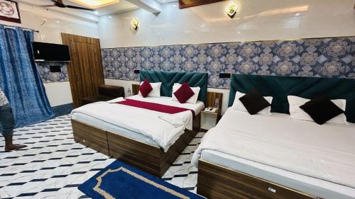 a hotel room with two beds and a tv at Hotel Jyoti Stay Inn 10 Min to Ram Tample in Ayodhya