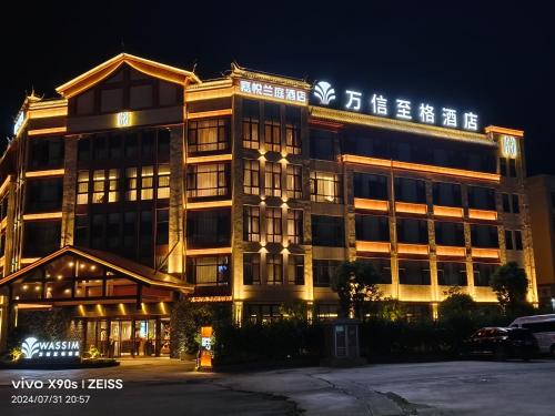 a building with a sign on top of it at night at 保山嘉悦兰庭万信至格酒店 in Baoshan