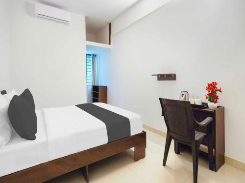 a bedroom with a bed and a desk and a chair at Collection O Sarjapura Formerly Blissful Stays in Bengaluru