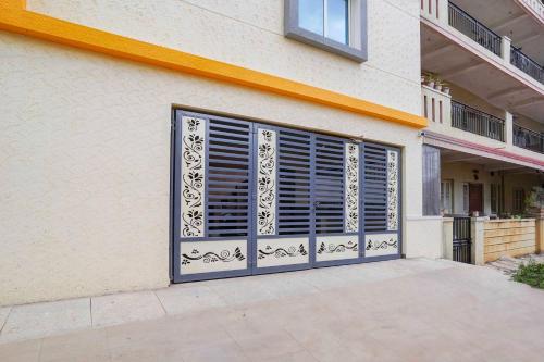 a building with a garage door with a window at Collection O Sarjapura Formerly Blissful Stays in Bengaluru