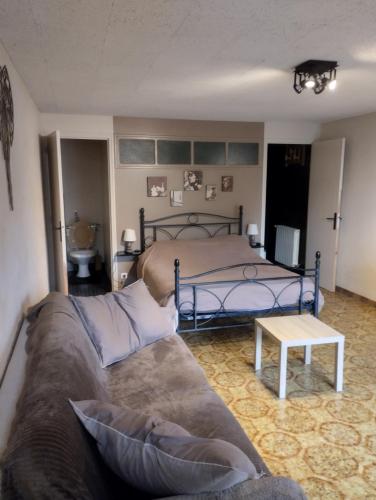 a living room with a bed and a couch at Studio de la bastide in Aubusson