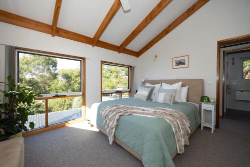 a bedroom with a bed and two windows at The Avenue in Anglesea