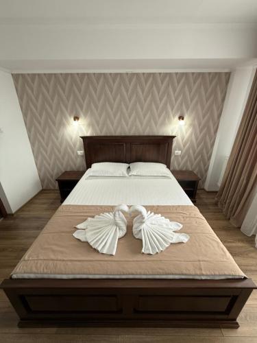 a bedroom with a bed with two white bows on it at Cabana Rares in Ranca