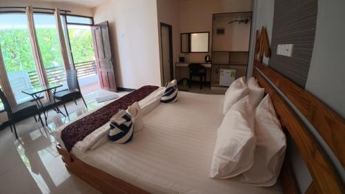 a bedroom with a large bed with pillows on it at Liberty Guesthouse Maldives in Mahibadhoo