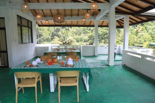 une salle à manger avec une table et des chaises vertes dans l'établissement King's Court Kandy, à Kandy