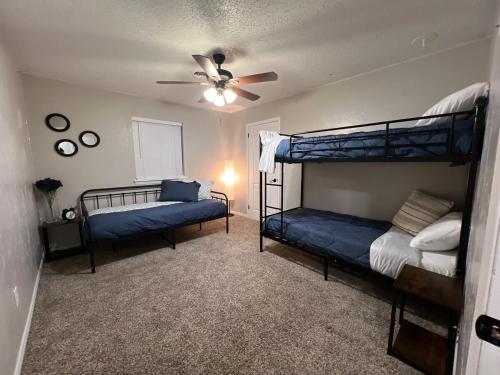 Un dormitorio con dos literas y un ventilador de techo. en Cozy Cul de sac 4 bed 2 bath, en Amarillo