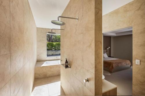 una camera da letto con un letto e un bagno con un lavandino di Sundance Estate - Summer Luxury a Yallingup