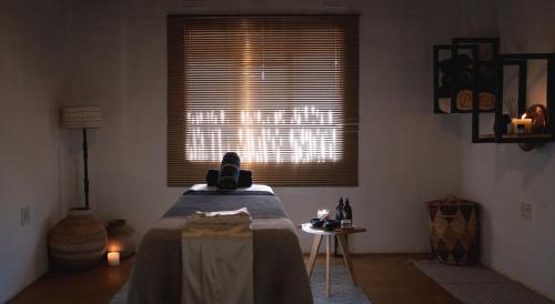 a room with a bed with a table and a window at Mashatu Lodge in Lentswelemoriti