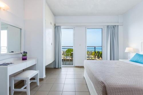 a bedroom with a bed and a view of the ocean at Aqua Marina in Rethymno Town