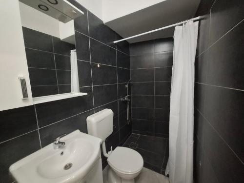 a bathroom with a white toilet and a sink at Konjic Stay in Konjic