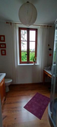 un salon avec une fenêtre et un tapis violet dans l'établissement Pilea, Maison à la campagne avec grand jardin, à Saint-Agnan-le-Malherbe