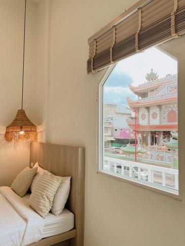 a bedroom with a window with a view of a building at LAIWAII HOME in Hat Yai