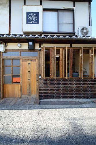 a building with wooden doors and a sign on it at 一棟貸し宿 ローカルプライド大和高田 in Yamatotakada