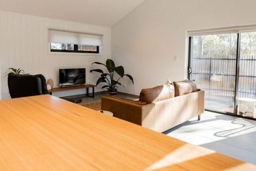 a living room with a table and a couch at Villa 2 - Greenstone Villas in St Helens
