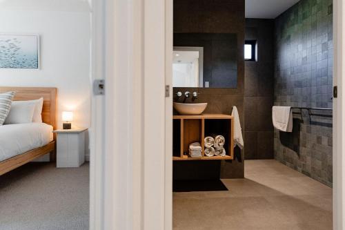 a bathroom with a bed and a sink in a room at Villa 2 - Greenstone Villas in St Helens