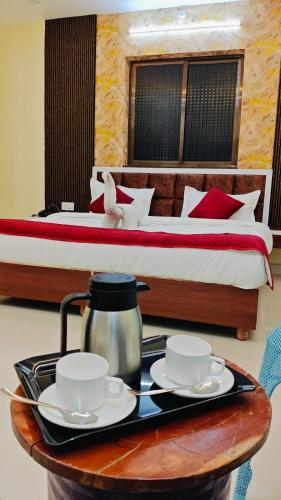 a hotel room with a bed and a tray with two tea cups at Hotel Kiran Palace and Mahi Galaxy in Osiān