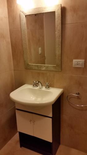 une salle de bain avec un lavabo et un miroir dans l'établissement Centro Cívico departamentos, à San Carlos de Bariloche
