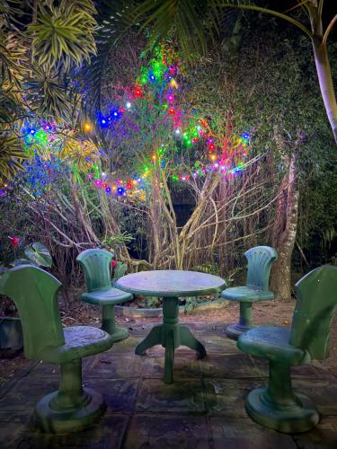 a table and four chairs and lights at Solal Villa in Aluthgama