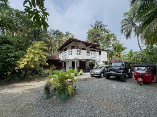 a house with cars parked in front of it at Solal Villa in Aluthgama