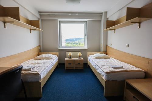 two beds in a room with a window at DS Za Kolumnami in Krakow