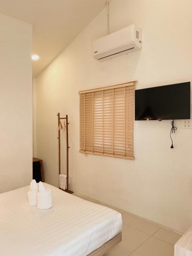 a bedroom with two beds and a air conditioner at LAIWAII HOME in Hat Yai