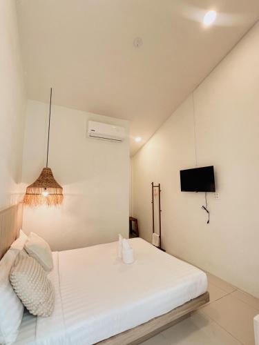 a bedroom with a white bed and a tv at LAIWAII HOME in Hat Yai