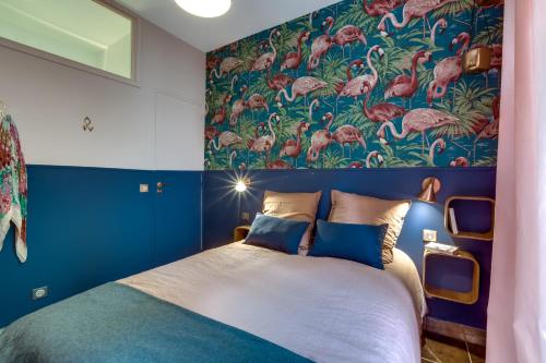 - une chambre avec un grand lit et un mur coloré dans l'établissement La Casa Nissarte, à Nice