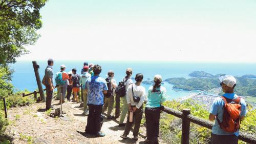 a group of people standing on a mountain looking at the ocean at Rulo Classic Garden in Shishikui