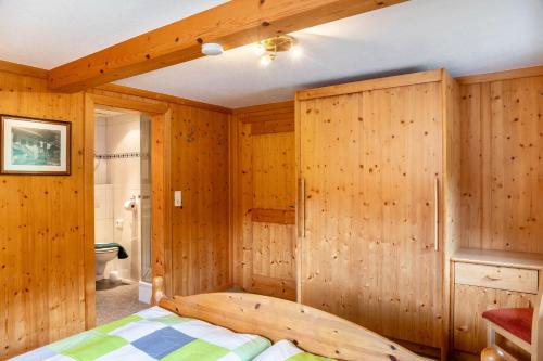 a bedroom with wooden walls and a bed in a room at Gasthaus Mamoosen in Penning