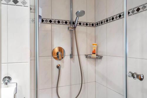 a shower with a shower head in a bathroom at Gasthaus Mamoosen in Penning