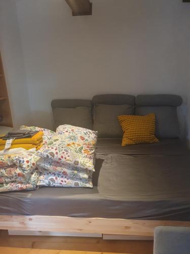a bed with pillows on it in a room at Brookside Old Village Studio at a walking distance from Bled in Bohinjska Bela