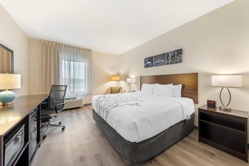a hotel room with a bed and a desk at Sleep Inn & Suites Norman near University in Norman
