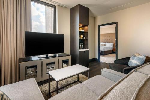 a living room with a couch and a television at Cambria Hotel Houston Downtown Convention Center in Houston