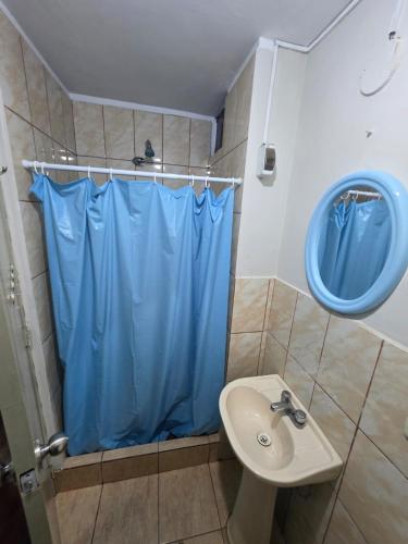 a bathroom with a blue shower curtain and a sink at RODRICH apartment 2 in Lima