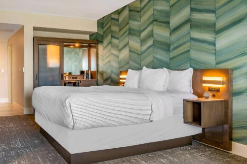 a bedroom with a large bed with a striped wall at Cambria Hotel Ocean City - Bayfront in Ocean City