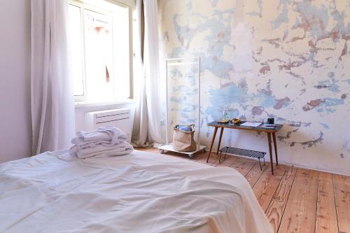 a bedroom with a bed and a window and a table at Alma ART B&B in Dobrovo
