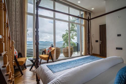 a bedroom with a bed and a large window at Alaya Stays Trios Top Pet Friendly Apartments in Mukteswar