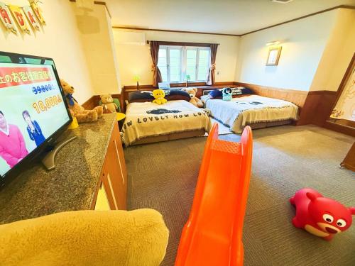 a bedroom with two beds and a flat screen tv at Ikaho Kids Paradise Hotel - Vacation STAY 56430v in Shibukawa