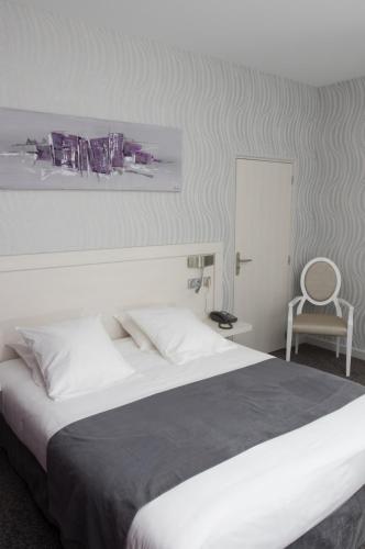 a bedroom with a large bed and a chair at Domaine du Revermont - Logis Hotel in Passenans