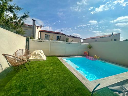 a small backyard with a swimming pool and a chair at Belle chambre dans villa neuve avec piscine in Perpignan