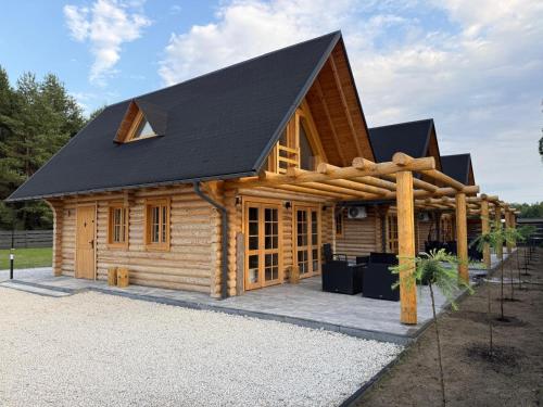 a log cabin with a black roof at Balujemy w Radawie in Radawa