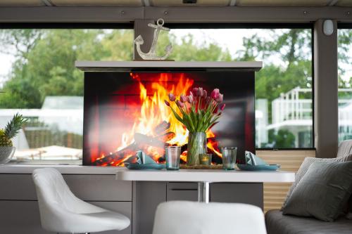 a fireplace in a living room with a vase of flowers at Lieblingsplatz Parey - schwimmendes Living Luxboot in Parey