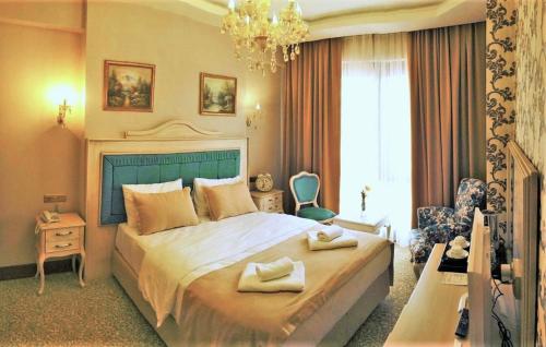 a bedroom with a large bed with two towels on it at Vendome Hotel in Eskisehir