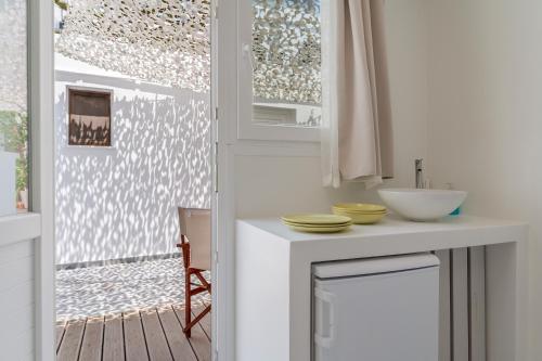 Una cocina con encimera con fregadero y ventana. en A Tinian Room 4, en Tinos