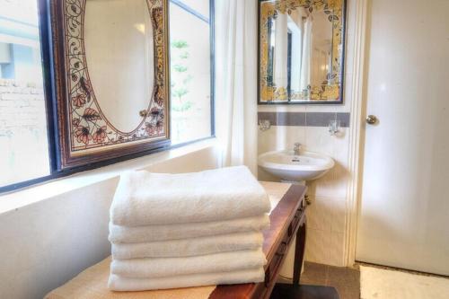 a bathroom with a sink and a pile of towels at Holiday Bungalow Suites - Sleeps Up To 26 Pax in Tanah Rata