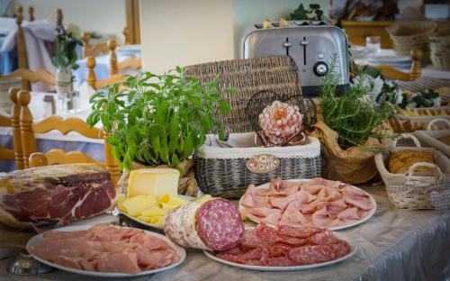 a table with different types of meats and cheese at Hotel Florida in Levico Terme