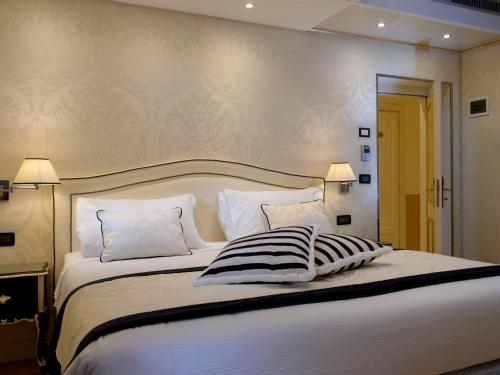 a bedroom with a large white bed with two pillows at Hotel Olimpia Venice, BW Signature Collection 3sup in Venice