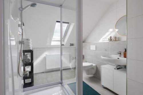 a white bathroom with a shower and a sink at Ferienwohnung 1 in Bad Salzuflen