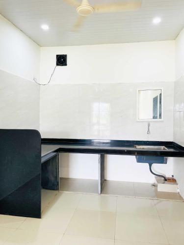 a large black desk in a white room at Hotel Amit Cafe and Lodging Bhimashankar in Ghoda